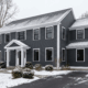 4f - J.E.P. Contracting | J.E.P. Contracting Snowy two-story blue house with white trim and a front porch. | J.E.P. Contracting
